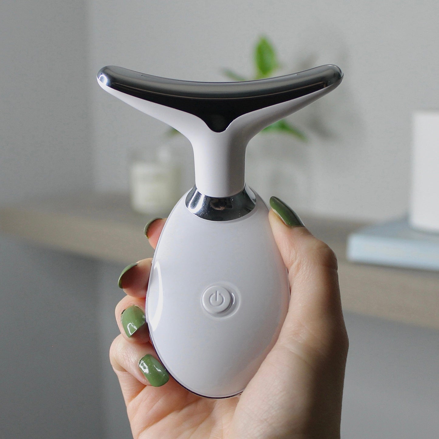 LumiLift LED Facial Sculptor handheld beauty device used on jawline for at-home facial massage and skin tightening treatment.