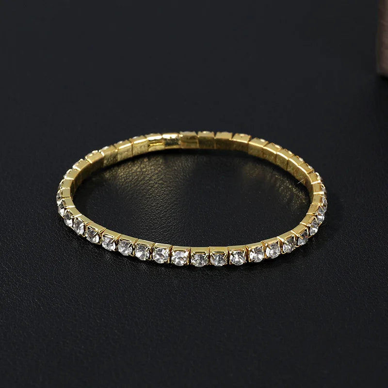 Pulseira "Aurum Royale Crystal Lux" – Uma pulseira de design clássico e atemporal, composta por uma fileira de zircônias brilhantes que refletem luz com elegância. Seu acabamento dourado realça o luxo e a sofisticação, sendo ideal para eventos formais ou como um presente memorável.