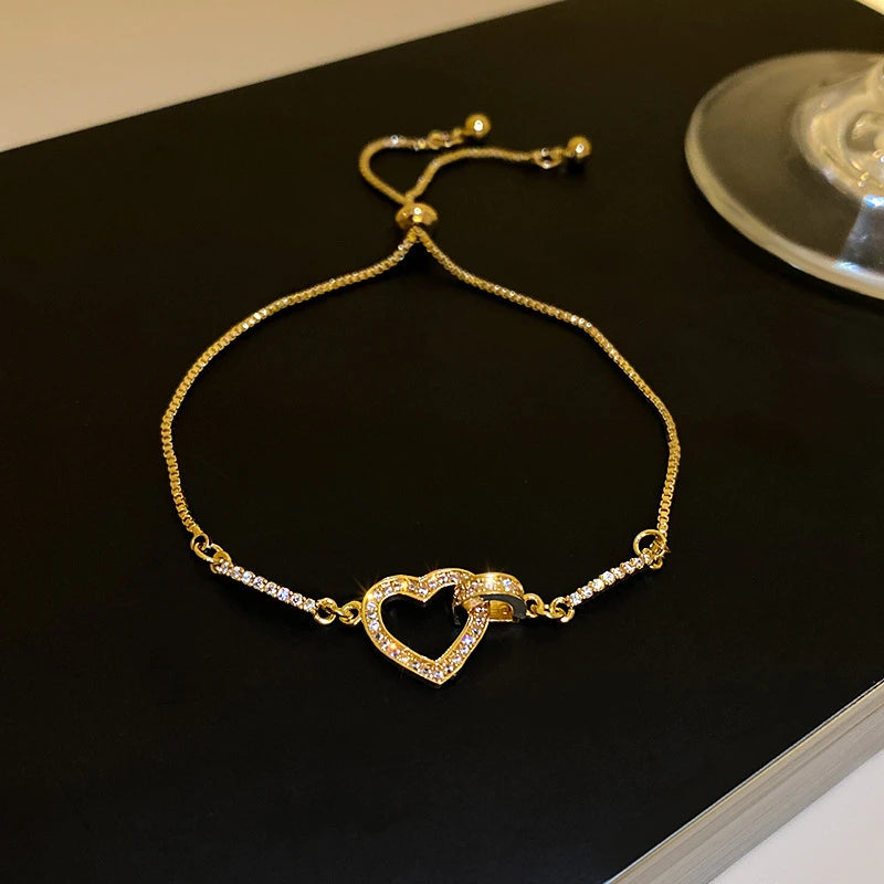 Pulseira ajustável "Coração Royale" com design refinado, composta por um charm central em formato de coração delicadamente cravejado de zircônias brilhantes, que irradiam elegância e romantismo. A corrente fina com ajuste deslizante garante conforto e praticidade. Ideal para presentear alguém especial ou para complementar seu look com sofisticação.